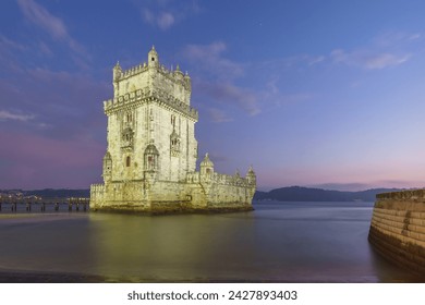 Illuminated Torre de Belem during evening twilight after sunset, Lisbon, Portugal