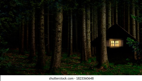 Illuminated window in a cabin in the woods at night