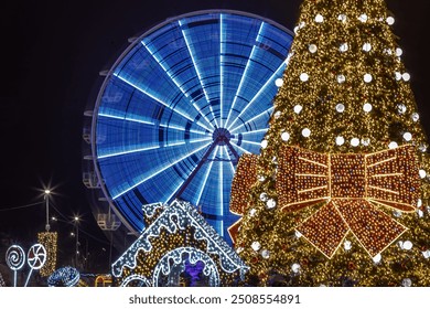 Illuminated Xmas ferris wheel and Christmas tree at night. Christmas market with decorations, ferris wheel blurred motion. Holiday nightlife - No people horizontal photography.  - Powered by Shutterstock