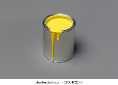 Illuminating yellow paint in a tin can, isolated on ultimate gray background. 2021 colors concept. Can of yellow paint on grey color, minimalist image