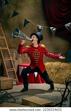 Illusionist or showman. Cinematic portrait of emotive man retro circus entertainer announces start of show isolated over dark retro circus backstage background. Concept of emotions, art, sales