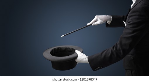 Illusionist white hand wants to conjure with magic wand from a black cylinder something