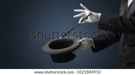 Illusionist white hand wants to conjure with magic wand from a black cylinder something