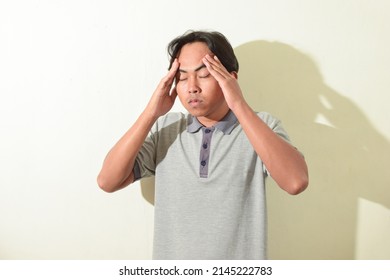 Illustration Of Dizzy, Tired Or Stressed Asian Man. Indonesian Man Pose Holding His Head While Closing His Eyes. Portrait Of Asian Man On White Background Isolated