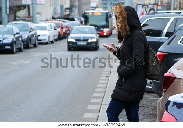 Illustration of the problem of\
the modern age. Called digital zombie. People are watching their\
smart phone with hood and headphones and don´t pay attention on the\
traffic. 