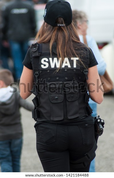 Illzach -\
France -9 June 2019 - portrait of woman with swat police uniform\
walking on back view  at fun car show\
event