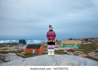 Ilulissat, Greenland - Jul 31, 2018: Young Inuit Woman In Traditional Clothing Posing For Photos In A Small Greenlandish Village.