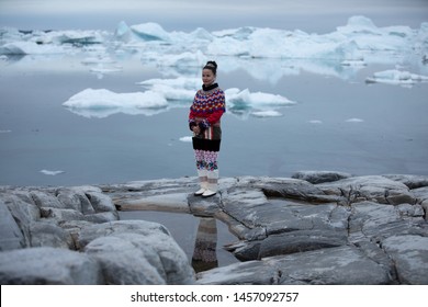 Ilulissat, Greenland - Jul 31, 2018: Young Inuit Woman In Traditional Clothing Posing For Photos In A Small Greenlandish Village.