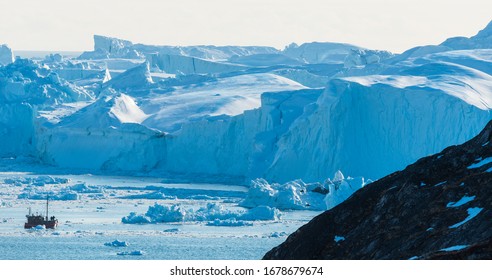ILULISSAT, GREENLAND - MAY 7, 2014: Tourist ship in Ilulissat Icefjord in front of glacier