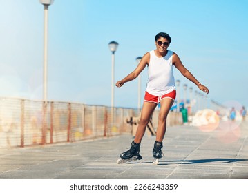 Im all about worrying less and rollerblading more. Shot of an attractive young woman rollerblading on a boardwalk.