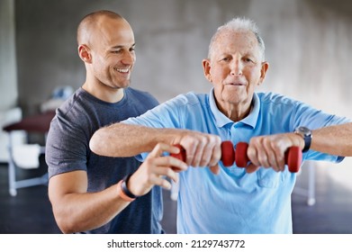 Im impressed with your progress. Shot of a physiotherapist helping a senior man with weights. - Powered by Shutterstock