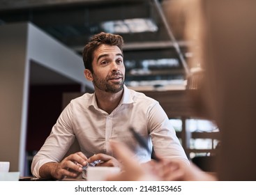 Im intrigued by your ideas... Do tell me more. Shot of a young businessman having a meeting with a colleague in an office. - Shutterstock ID 2148153465