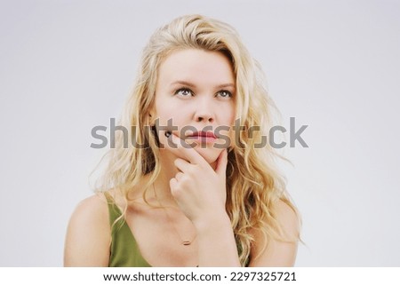 Im not sure what I think about this. Studio shot of a young woman looking thoughtful against a gray background.