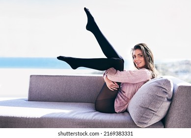 Im Not Your Regular Couch Potato. Full Length Shot Of An Attractive Young Woman Posing Provocatively On A Sofa.