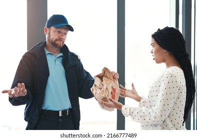 Im Sorry But Theres Nothing I Can Do About This. Shot Of A Handsome Delivery Man Negotiating With A Dissatisfied Female Customer In The Lobby.