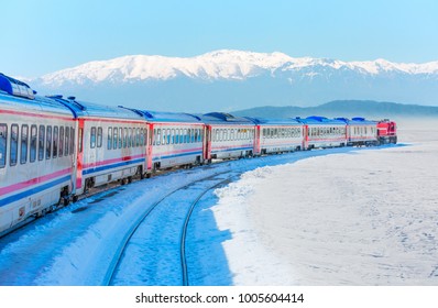 Red diesel train (East express) in motion at the snow covered railway platform - The train connecting Ankara to Kars - Turkey 