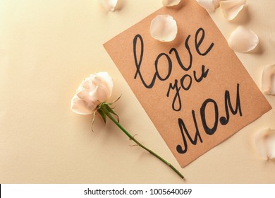 Karte mit den Worten "Love you mom" und Rose auf hellem Hintergrund. Grüße zum Muttertag