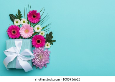 Happy Mother's Day, Women's Day, Valentine's Day or Birthday Pastel Candy Colors Background. Floral flat lay greeting card with beautifully wrapped present and copy space.