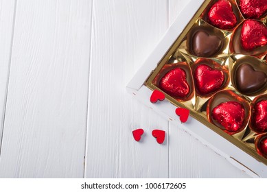 Délicieux bonbons au chocolat dans une boîte cadeau sur un fond en bois blanc. Carte de vœux pour la fête des mères, le 8 mars, un anniversaire, la Saint-Valentin, espace de copie à plat