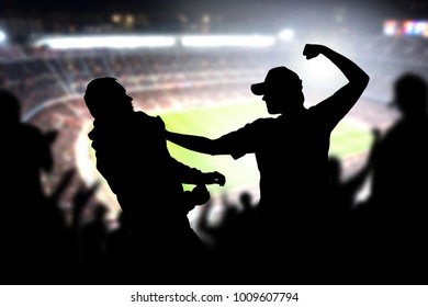 Vecht in een voetbalwedstrijd. Boze man raakt een andere toeschouwer in het publiek van de voetbalwedstrijd. Gewelddadige ruzie tussen twee fans van verschillende teams en clubs. Hooligans en geweld bij sportevenementen.