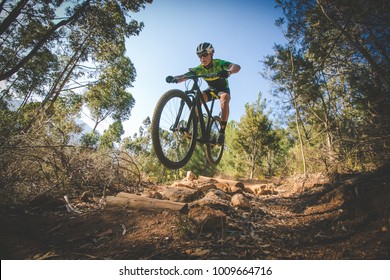 Brede hoekmening van een mountainbiker die bergafwaarts rijdt op een mountainbikeparcours in het bos