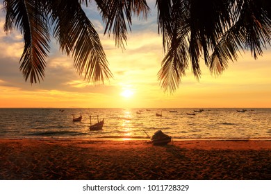 Západ slnka nad tropickou plážou s kokosovou palmou a loďou v Pattaya, Thajsko. Pattaya je raj v Thajsku. siluety paliem a úžasná zamračená obloha pri západe slnka na tropickej pláži.