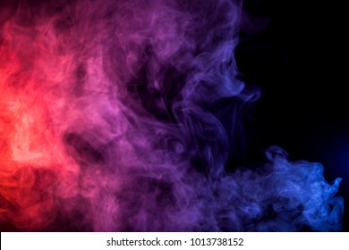 Colorful  pink and red  smoke clouds on dark background.Background of smoke vape