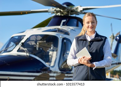 デジタル タブレットでヘリコプターの前に立っている女性パイロットの肖像画