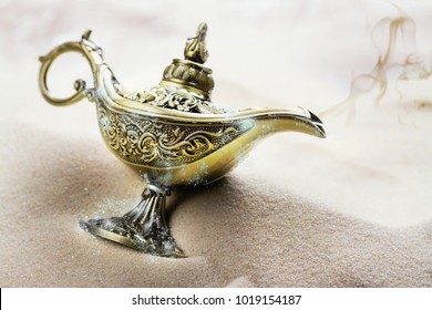 Aladdin magic lamp on the sand. Copy space