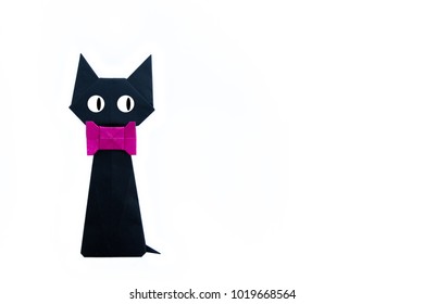 Origami pentru copii: pisică neagră și fundă magenta cu hârtie îndoită pe fundal alb izolat.