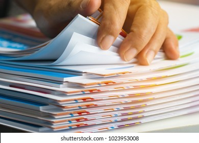 Businessman hands searching unfinished documents stacks of paper files on office desk for report papers, piles of sheet achieves with clips on table, Document is written, drawn,presented.