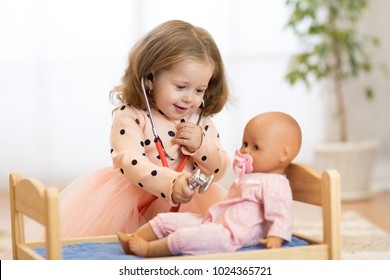 Cute child in kindergarten. Kid in nursery school. Little girl preschooler playing doctor with doll.