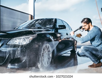 Auto wassen. Auto schoonmaken met water onder hoge druk.