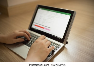女の子は、Microsoft Excel プログラムを使用してラップトップに入力しています。