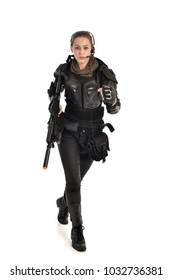 Porträt in voller Länge des weiblichen Soldaten, der schwarze taktische Rüstung hält, die eine Waffe hält, lokalisiert auf weißem Studiohintergrund.