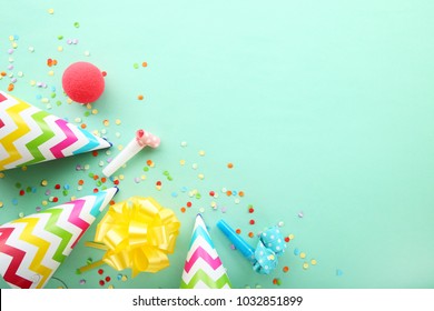 Fødselsdagsfest kasketter, blæsere og konfetti på mintbaggrund