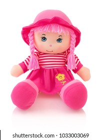 Pink plushie doll isolated on white background with shadow reflection. Cute pinky rag baby doll sitting on white underlay. Nice contemporary rag baby with pink hair. Modern joyfully rag baby with cap.