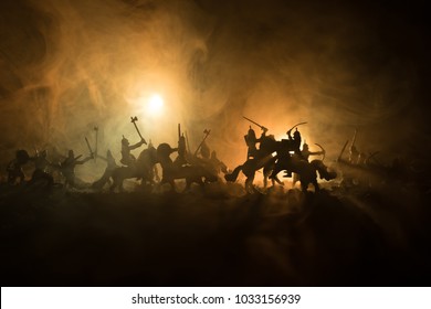 騎兵と歩兵による中世の戦闘シーン。個別のオブジェクトとしての人物のシルエットは、暗い色調の霧の背景で戦士間で戦います。夜のシーン。セレクティブ フォーカス