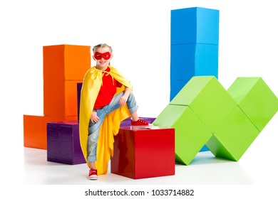 Supergirl con capa amarilla y máscara roja en lugar de ojos parada sobre un cubo aislado en blanco