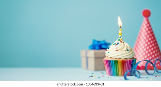 誕生日パーティーの背景にカップケーキ、パーティーハット、プレゼント