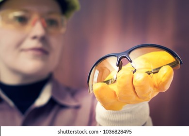 Seorang pekerja wanita menawarkan kacamata pengaman