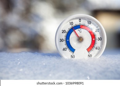Termometer med celsius skala placeret i en nysne, der viser minus 10 grader - koldt vintervejr koncept