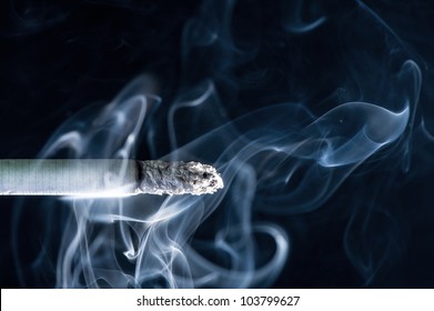 Brennende Zigarette mit Rauch auf schwarzem Hintergrund