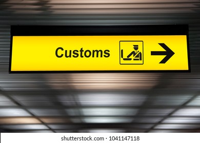空港の税関は、国際線ターミナルの空港の天井からアイコンと矢印がぶら下がっているサインを宣言します。輸入および輸出の概念の税関申告