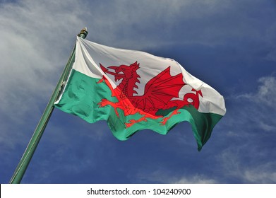 De Welshe vlag tegen een blauwe lucht. Bewegingsonscherpte aan het uiteinde van de vlag. Ruimte voor tekst in de lucht.