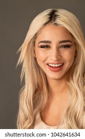 Gorgeous blonde woman portrait smiling while looking at camera