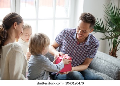Hijo pequeño presentando un regalo para papá, un niño lindo sosteniendo una caja haciendo un regalo sorpresa para papá, niños felicitando a un padre feliz y emocionado con cumpleaños, una familia joven celebrando el concepto del día del padre juntos