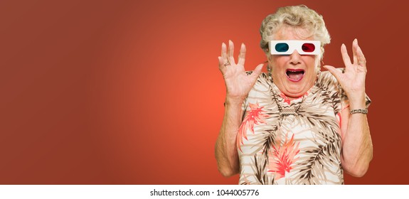 Mujer mayor asustada viendo películas en 3d gritando sobre fondo rojo