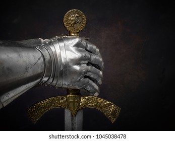 Ein schönes altes Schwert des Ordens der Tempelritter und ein eiserner Ritterhandschuh auf einem dunklen schönen Hintergrund.