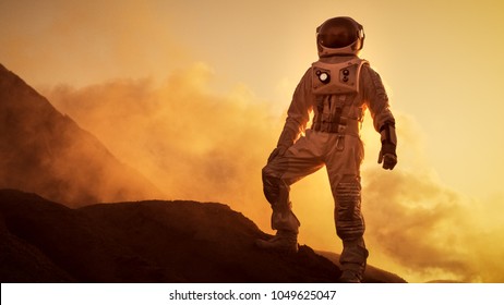Silhouette des Astronauten, der auf dem felsigen Berg des außerirdischen roten Planeten / Mars steht. Erste bemannte Mission auf dem Mars. Weltraumforschung, Kolonisation.
